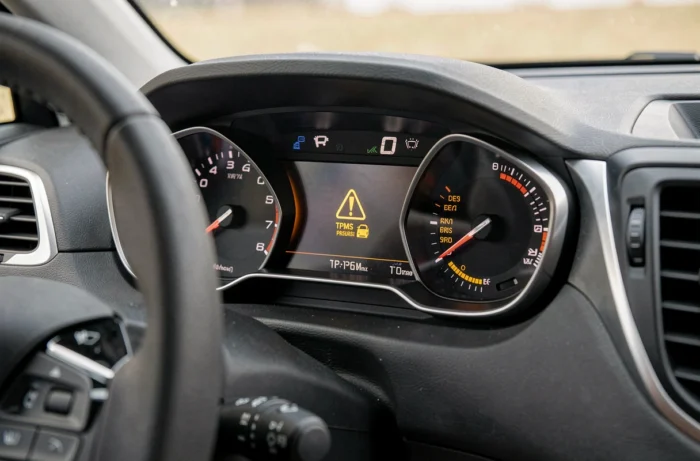 Gros plan sur le voyant de pression pneu allumé sur le tableau de bord numérique d'une Peugeot 2008